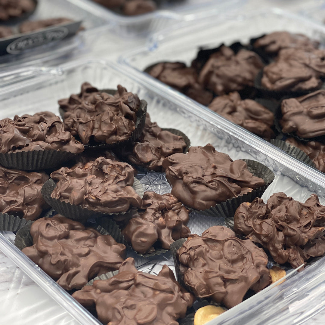 Variety box of pecan, cashew, peanut, and almond nut clusters covered in our delicious milk or dark chocolate.