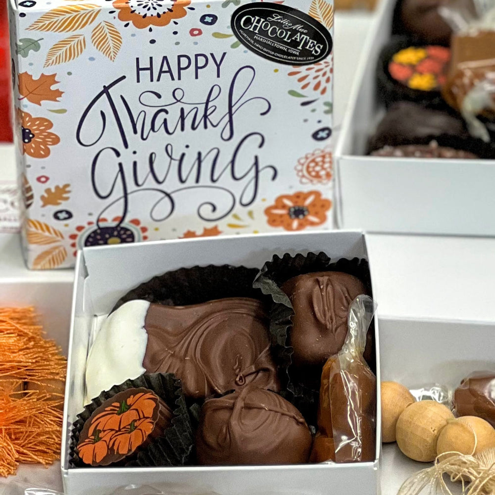 The deluxe assortment box says Happy Thanksgiving  box with all of your favorites in this cute fall gift box including a soft center cream, truffle, sea salt caramel, chocolate covered caramel and wrapped caramel!