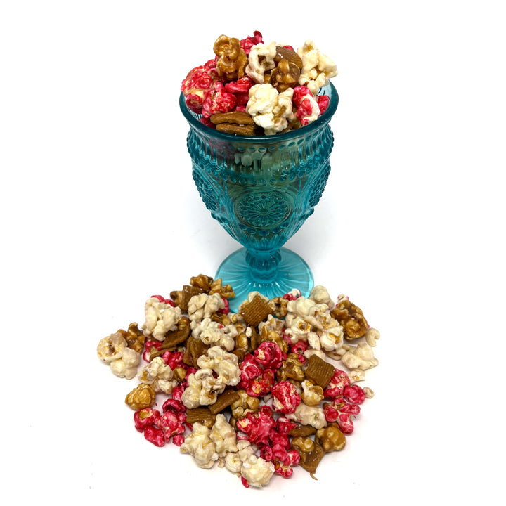 Our Strawberry Cheesecake popcorn has fruity strawberry popcorn, rich cheesecake white chocolate popcorn, and buttery caramel popcorn. Topped off with graham crackers for the perfect touch!