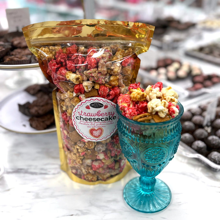 Our Strawberry Cheesecake popcorn has fruity strawberry popcorn, rich cheesecake white chocolate popcorn, and buttery caramel popcorn. Topped off with graham crackers for the perfect touch!