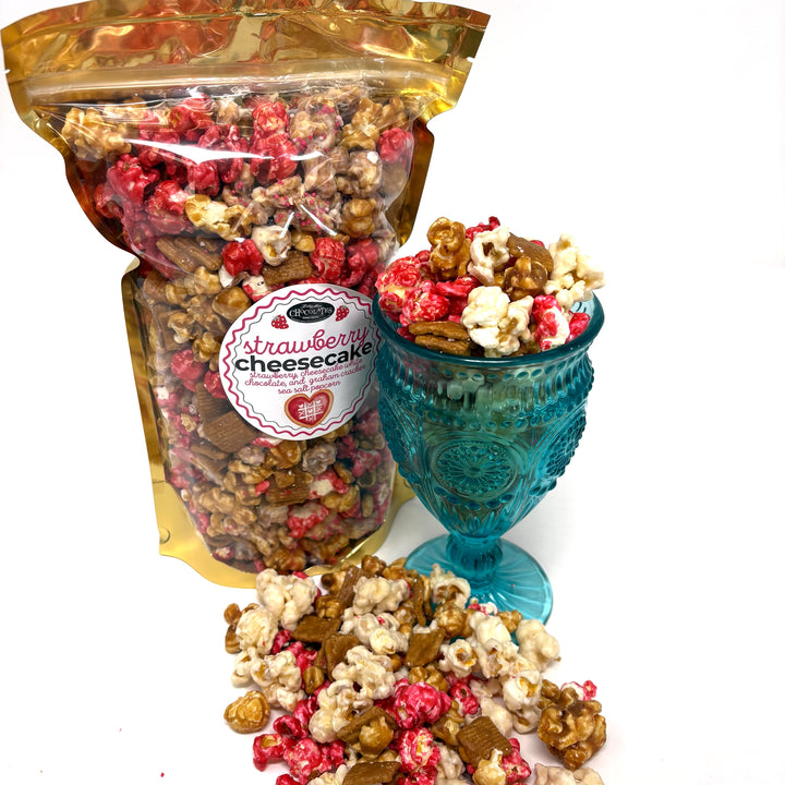 Our Strawberry Cheesecake popcorn has fruity strawberry popcorn, rich cheesecake white chocolate popcorn, and buttery caramel popcorn. Topped off with graham crackers for the perfect touch!